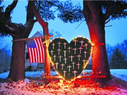 Un altar improvisado con cruces para las víctimas de la masacre de Sandy Hook se encuentra al frente de una casa en Newtown. AP /
