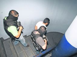 Agentes federales conducen a un presunto delincuente, tras un operativo donde liberaron a una persona.  /