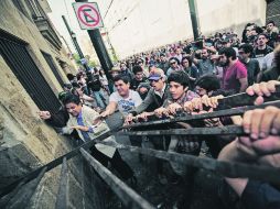 Docenas de manifestantes rompieron la protección de una de las ventanas traseras del Congreso, para después ingresar al recinto.  /