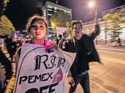 Dos jóvenes se manifiestan en contra de la reforma energética, que, a su consideración, “crucifica” a Pemex.  /