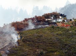 Bomberos tratan de contener el fuego en el área de Pfeiffer Ridge. AP /