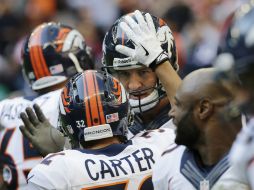 Peyton Manning es felicitado por sus compañeros tras lograr el récord de pases de anotación. AP /