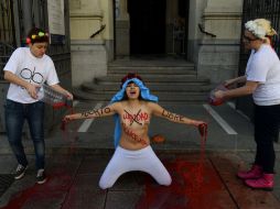 Una miembro de Femen se arrodilló en el suelo y desnudó sus pechos. AFP /