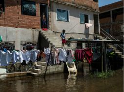 Un niño intenta pescar en una calle inundada del estado de Espírito Santo en Brasil. AFP /