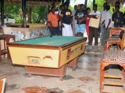 Clientes del restaurante Tandoori observan la escena del crímen tras la explosión de una granada. AP /