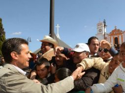 Filas de personas se formaron en los alrededores de la plaza local para saludar al Presidente Peña. ESPECIAL /