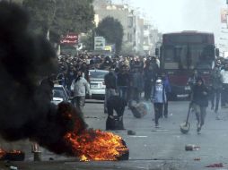 Manifestantes responden con piedras después de que la policía antidisturbios disparase gas lacrimógeno. EFE /