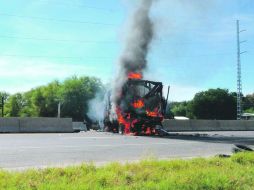 Un camión de pasajeros arde en llamas en una carretera cercana a Parácuaro, Michoacán. AP /