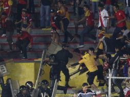 Aficionados del Morelia se enfrentan con policías durante el partido de la primera jornada ante Querétaro. EFE /