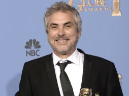 Alfonso Cuarón sostiene el premio al momento de lucir una gran sonrisa. AFP /