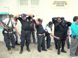 PARADOJAS. Autodefensas encapuchados registran a policías de Nueva Italia, municipio de Múgica, Michoacán. AP /