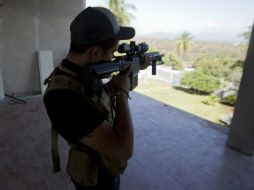 Un integrante de autodefensa se atrinchera en uno de los puntos de revisión de Nueva Italia, Michoacán. AP /