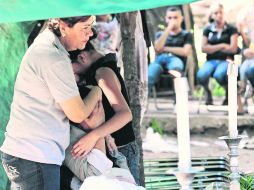 Desconsuelo. La familia de una de las personas asesinadas por militares llora durante el velorio.  /