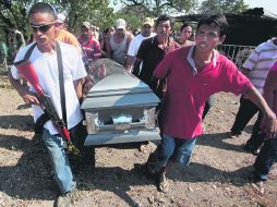 Miembros de las autodefensas de Antúnez cargan el féretro de Rodrigo Benítez, muerto a manos del Ejército. AP /
