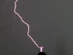 Fotografía que capturó el momento exacto en el que el fenómeno meteorológico impactó en la mano derecha del Cristo. EFE /