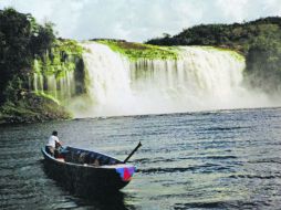 El paisaje. Un pemón en su curiara divisando la Cascada de Las Golondrinas sobre la Laguna de Canaima. ESPECIAL /