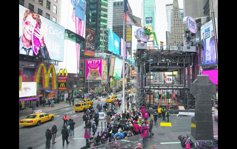 En pleno corazón de Times Square, unos trabajadores arman un andamio para una televisora. AP /