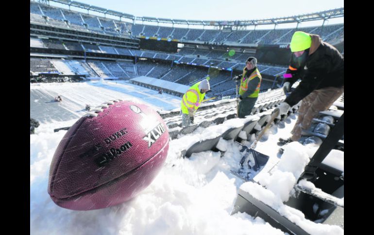 A marchas forzadas. Trabajadores del Estadio MetLife remueven la nieve de las gradas. AP /