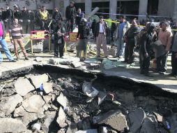 Policías observan el socavón que dejó una de las explosiones de ayer, frente a la la Dirección General de Seguridad en El Cairo. EFE /