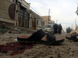 Un grupo de hombres camina por el lugar donde dos civiles murieron y otros cuatro resultaron heridos por el impacto de proyectiles. EFE /