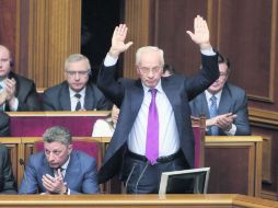 Pese a la renuncia del primer ministro, Mykola Azarov (de pie), el futuro político del presidente aún es incierto. AP /