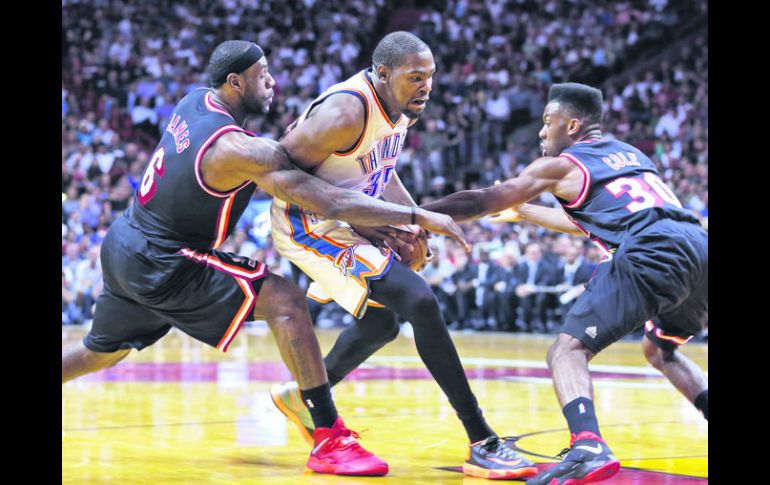 Doble equipo. LeBron James y Norris Cole cubren a Kevin Durant en su intento por colarse hasta la canasta. AP /