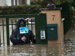 Un hombre atraviesa una puerta en una calle completamente inundada de Roma. EFE /
