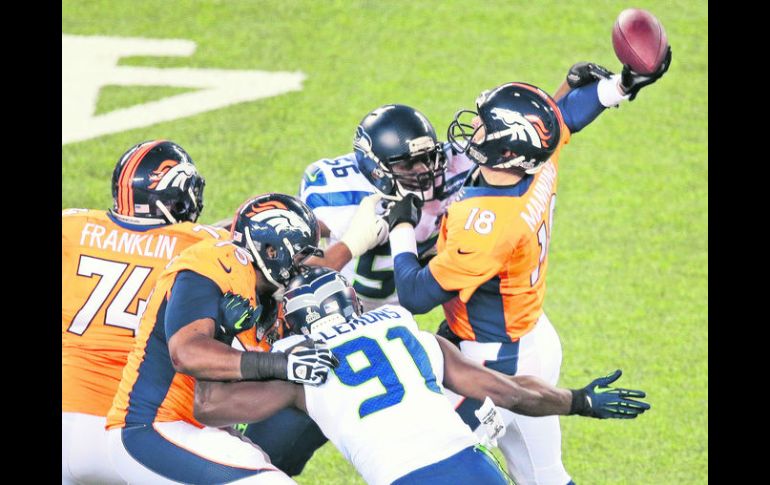 El apoyador de Seattle, Cliff Avril (56), alcanza a golpear al mariscal de campo de Denver, Peyton Manning. AP /