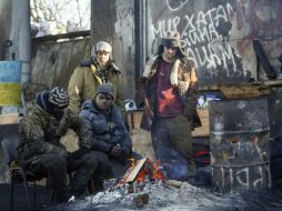 Manifestantes se calientan alrededor de una hoguera en una barricada realizada en la ciudad de Kiev. EFE /