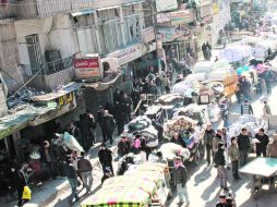 Cientos de sirios se concentran con sus pertenencias en el distrito de Bustan al-Qasr, en la ciudad de Alepo. AFP /