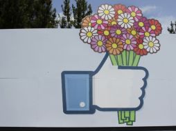 Flores se agregan a una señal de Facebook frente a la sede de la misma. AP /