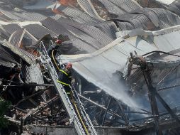 Bomberos lanzan agua al edificio siniestrado para tratar de apagar el fuego. AFP /