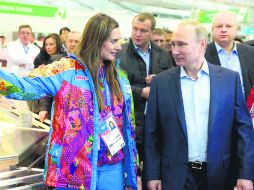 Por aquí. La saltadora con garrocha rusa, Yelena Isinbayeva, le muestra la Villa Olímpica al mandatario Putin. AP /