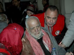 Un civil sirio es ayudado por miembros de la Media Luna Roja a su llegada a un centro de evacuación. EFE /