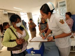 Una enfermera habla con una enferma de influenza. ARCHIVO /