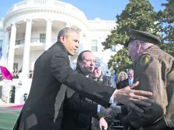 EN LA CASA BLANCA. Barack Obama y François Hollande saludan a un veterano de guerra ante de su reunión privada.  /