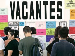 Un grupo de personas que buscan empleo se acercan a ver ofertas de trabajo. ARCHIVO /