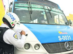 'Fuera'. Un policía se apoya en una unidad de la ruta 101 para elaborar un reporte  /