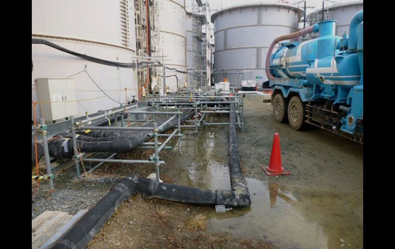 El agua comenzó a salir desde la parte superior del tanque y fluyó a través de un canalón que hay acoplado al contenedor. EFE /