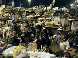 Manifestantes preparan bombas molotov dentro del campamento situado en la plaza central de Kiev. AFP /