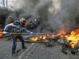 Un manifestante lanza objetos a la hoguera que se encuentra en la plaza principal de Kiev. EFE /