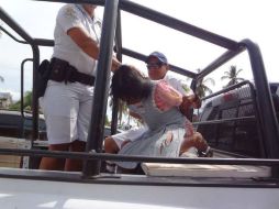 En la imagen se ve como los elementos de la policía suben a la detenida a la patrulla. @JaguarAguilar. ESPECIAL /