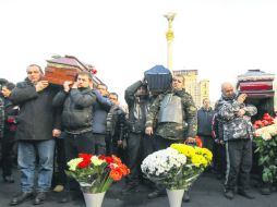 Decenas de personas asisten al funeral de varios manifestantes que murieron durante los enfrentamientos en Kiev. EFE /