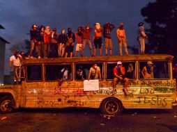 Los manifestantes, en lo alto de un autobús destrozado en protesta contra el gobierno de Nicolás Maduro en San Cristóbal, Venezuela. AFP /
