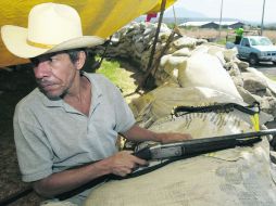 Un autodefensa vigila el paso de autos. Las sospechas sobre la infiltración de narcotraficantes son retos nuevos para los comunitarios. EFE /