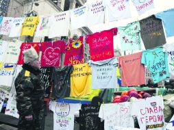 Un habitante de Kiev lee mensajes en decenas de camisetas ubicadas en la Plaza de la Independencia. EFE /