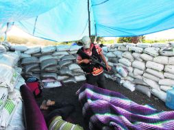 Atentos. Un miembro de las autodefensas vigila una de las entradas de Apatzingán. AFP /