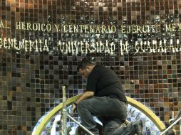 Trabajadores colocan las letras doradas.  /