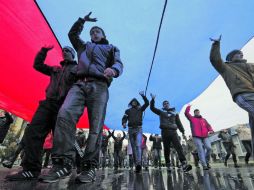 Manifestantes prorrusos caminan frente al Parlamento de Crimea con una enrome bandera. AFP /