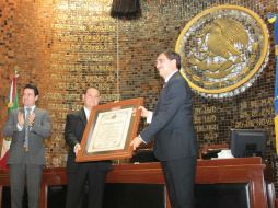 El rector Tonatiuh Bravo recibe el pergamino con el decreto que da este título a la Universidad. ESPECIAL /